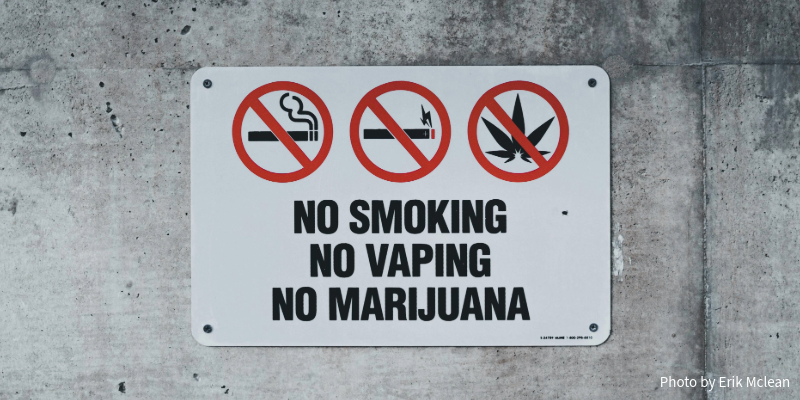 On a concrete wall is a sign reading in all caps: "No smoking No vaping No marijuana"